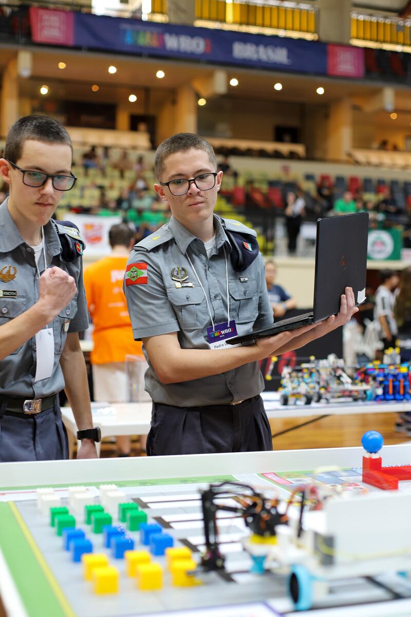Alunos analisando a programação do robô durante a disputa na WRO Brasil